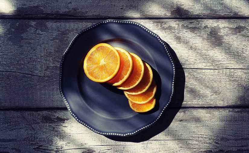 sliced of orange fruits on black plate